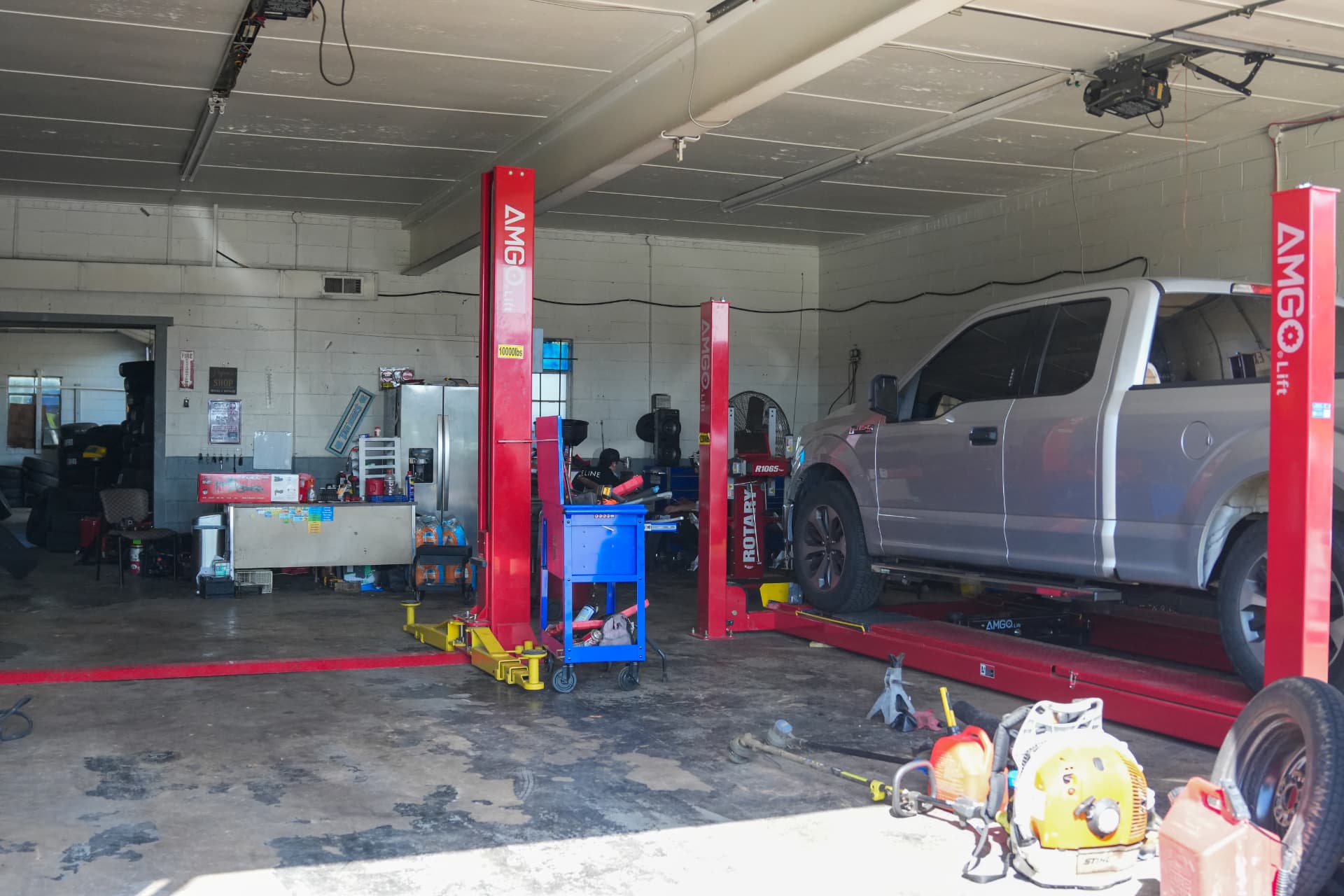 Inside the American Tire and Racing service bays with vehicles on the lifts
