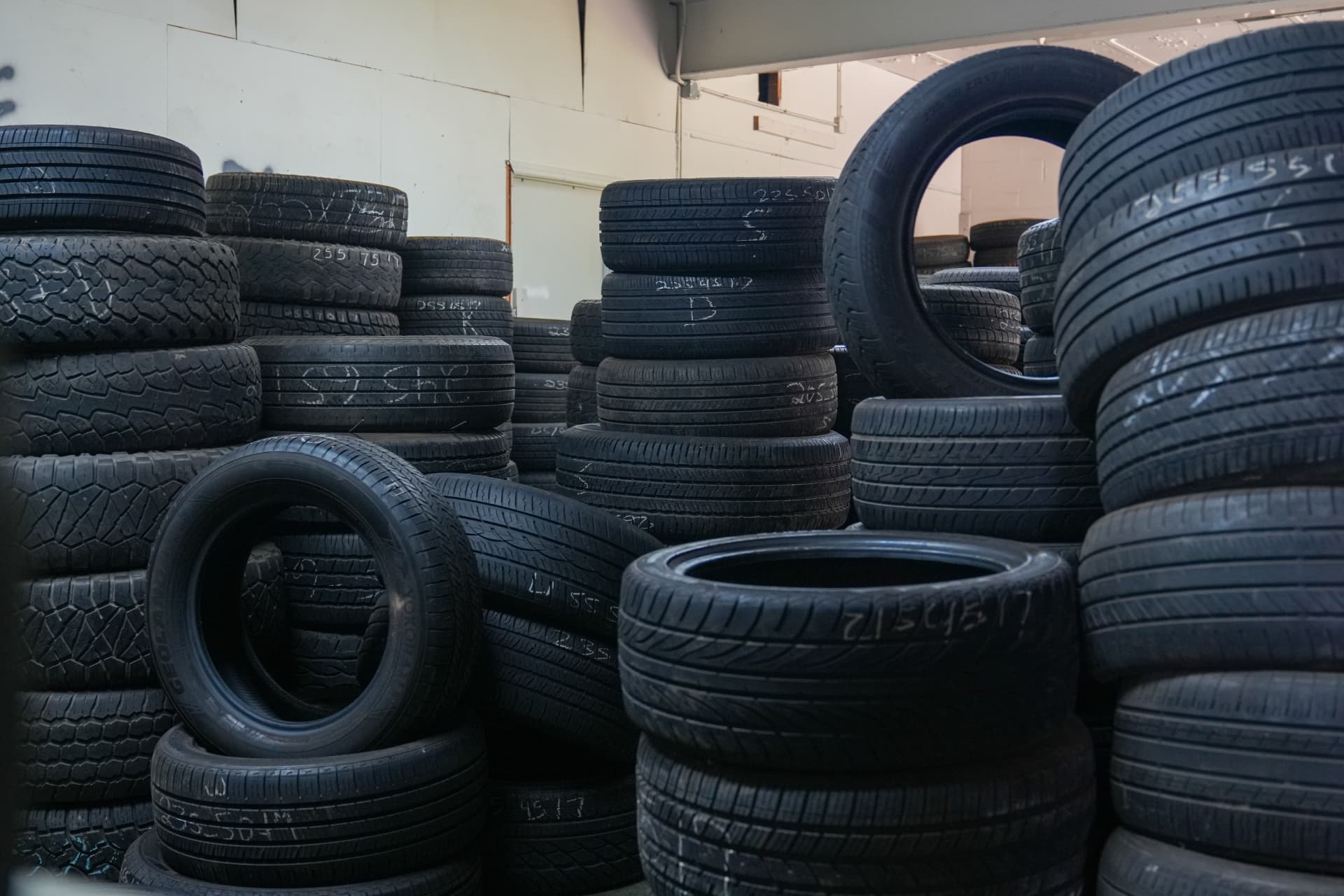 Stacks of quality used tires sorted by size in the shop